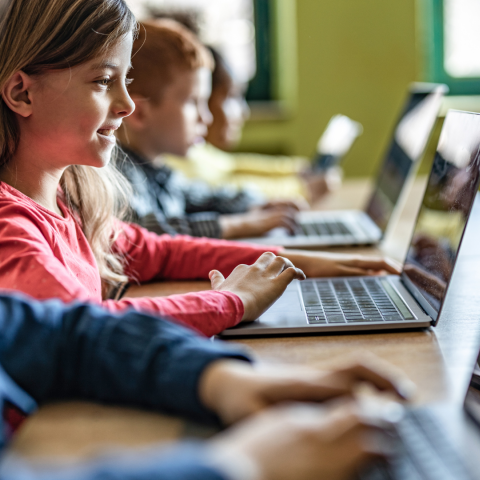 Estudantes do ensino fundamental usam computadores individualmente durante uma aula.